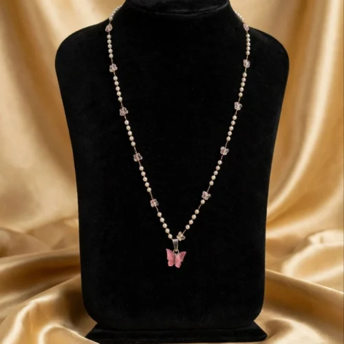 Pink butterfly pendant on faux pearl and pink glass butterfly bead chain displayed on black velvet bust