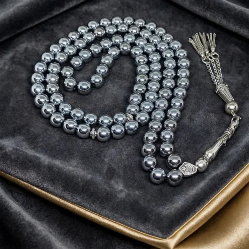 Silver hematite-look 99-bead misbaha with silver-tone crescent bead and chain tassel on grey velvet