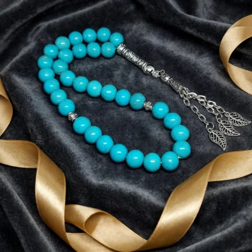 Turquoise-look 33-bead misbaha with silver-tone imame and leaf charm chain tassel on dark velvet with gold ribbon