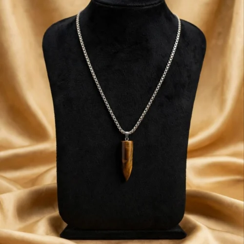 Tiger-eye-look bullet pendant on silver-tone box chain displayed on black velvet bust