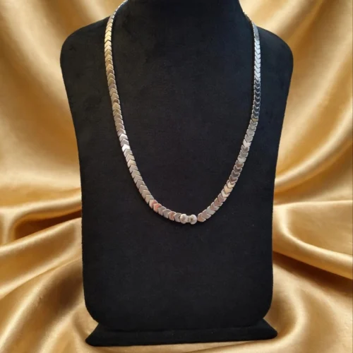 Hematite-look chevron bead necklace with small shell-shaped centre bead on black velvet bust