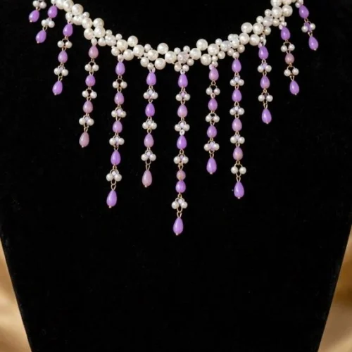 Woven white faux pearl collar necklace with lilac teardrop bead fringe on black velvet bust