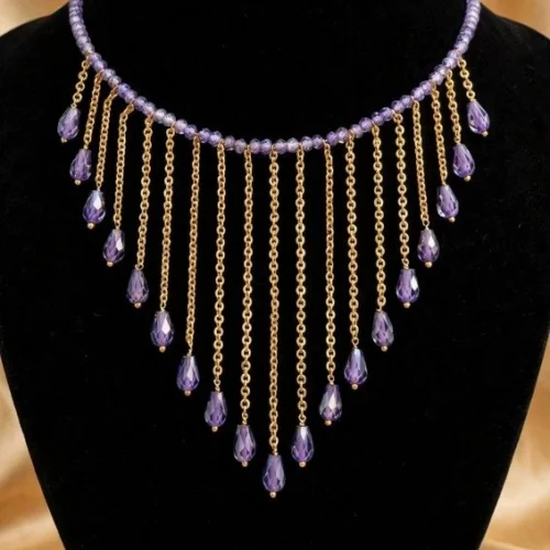 Lavender crystal bead necklace with gold-tone chain fringe and purple crystal teardrops on black velvet bust