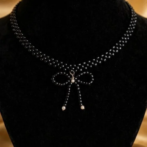 Black seed bead choker with beaded bow and tiny faux pearls on black velvet bust