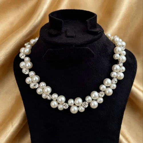 Chunky white faux pearl cluster collar with crystal rhinestone beads on a black velvet bust